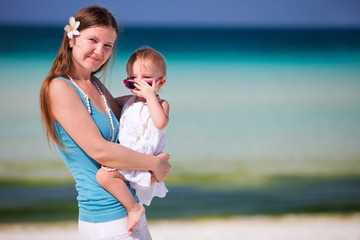 Wall Mural - Young mother holding baby daughter