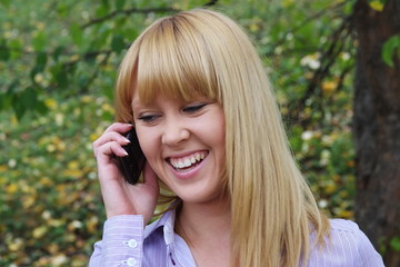 Wall Mural - a young girl on nature speaks by phone