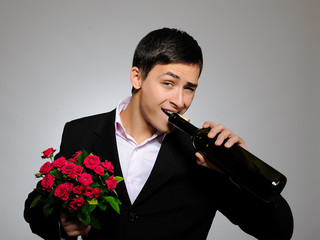 Wall Mural - handsome romantic young man holding rose flower and vine bottle