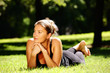 © Kalim - Young woman lying in the park