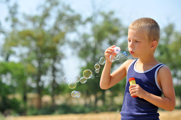 Boy blowing soap bubbles