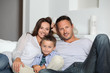 © goodluz - Closeup of parents and child relaxing at home on sofa