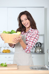 Wall Mural - Beautiful woman stading in kitchen with apron