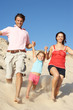 © Monkey Business - Family Enjoying Beach Holiday Running Down Dune