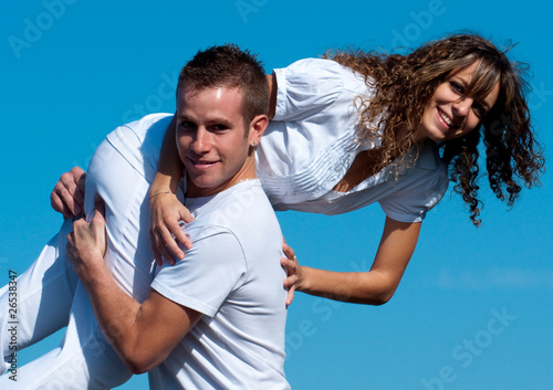 jeune homme qui porte une jeune femme - ciel bleu Photo Stock | Adobe Stock