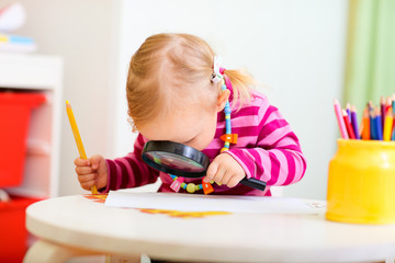 Canvas Print - Toddler girl looking through magnifier