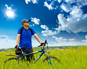 Wall Mural - man with bike on green field