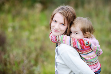 Wall Mural - A girl having a piggyback ride on her mom