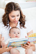 © WavebreakMediaMicro - Attentive mother reading a book to her adorable baby