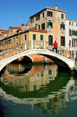 Wall Mural - Vertical oriented imeage of small bridge over canal in Venice.