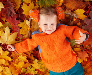 Wall Mural - girl child in autumn orange leaves.