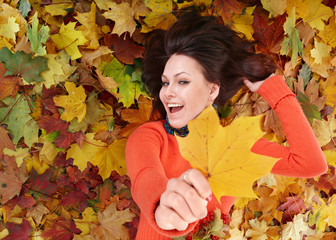 Wall Mural - young woman in autumn orange leaves.