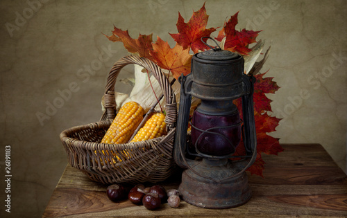 Fototapeta na wymiar Herbstliches Stilleben mit Petroleumlampe und Mais in Weidenkorb