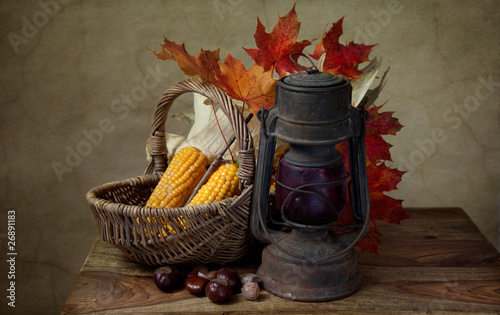 Naklejka na szybę Herbstliches Stilleben mit Petroleumlampe und Mais in Weidenkorb