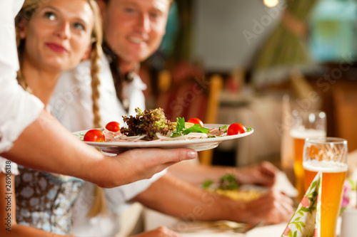 Fotografie, Obraz Kellnerin serviert in bayerischem Restaurant