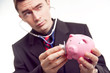 © originalpunkt - businessman holding piggy bank and stethoscope