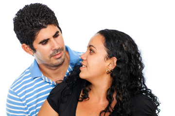 Young latin couple looking at each other with love on a white ba