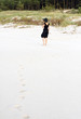 Młoda piękna kobieta spacerująca po plaży