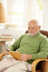 Sticker - Older man relaxing at home, reading book