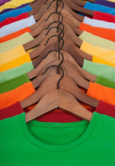 Wall Mural - Many vibrant t-shirts on wooden hangers