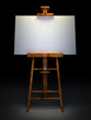 Wooden easel with blank canvas isolated on black