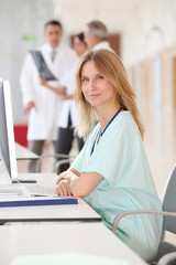 Wall Mural - Portrait of beautiful nurse in front of medical people