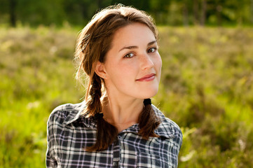 Pretty girl with pigtails relaxing outdoors