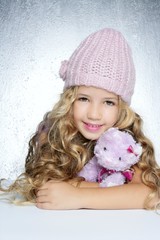 Wall Mural - winter fashion cap little girl hug teddy bear smiling