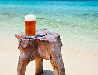 Glass of beer on a beach