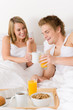 © CandyBox Images - Luxury hotel honeymoon breakfast - couple in bed