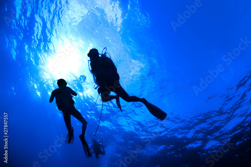 Dekoracja na wymiar scuba-divers-w-sylwetce-z-sunburst-na-niebieskim-tle