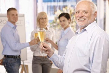 Canvas Print - Senior businessman raising champagne glass