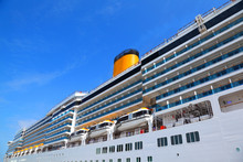 Large Cruise Ship With Yellow Funnel And Blue Balcony