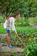 © HamsterMan - Young woman with hoe working in the garden bed