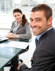 Cheerful business people sitting at a table with a laptop