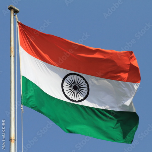 flag of India with flag pole waving in the wind over blue sky Stock