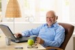© nyul - Portrait of happy senior man with computer