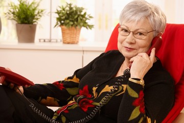 Canvas Print - Senior lady using landline phone