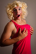 A man dressed as a woman holding his breasts
