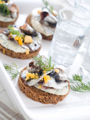 Wall Mural - Anchovy canapes garnished with dill and yolk and vodka