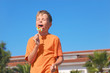 © Pavel Losevsky - little boy in orange shirt licking multicolored lollipop