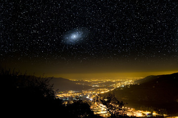 Wall Mural - the universe above city lights. the triangulum galaxy, m33.