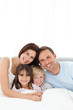 © WavebreakMediaMicro - Portrait of a joyful family sitting on the bed