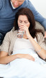 © WavebreakMediaMicro - Sick woman drinking water lying on the sofa