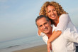 © goodluz - Portrait of happy mature couple at the beach