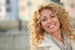 © goodluz - Portrait of smiling blond woman in town