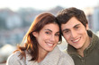 © goodluz - Portrait of young smiling couple in town
