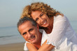 © goodluz - Portrait of happy mature couple at the beach