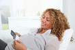 © goodluz - Pregnant woman laying on sofa with sonogram of future child