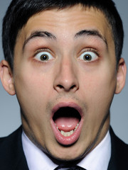 Portrait of funny surprised business man in formal suit and blac